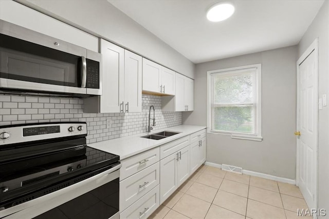 209 Monica Dr, Saint Louis, MO 63127 - kitchen with appliances with stainless steel finishes, light countertops, tasteful backsplash, and white cabinets