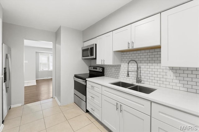 209 Monica Dr, Saint Louis, MO 63127 - kitchen with appliances with stainless steel finishes, decorative backsplash, and light countertops