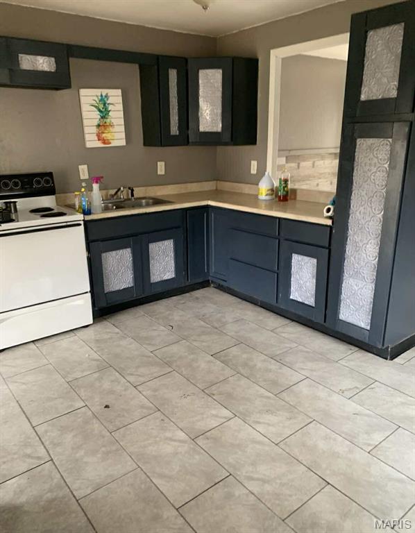 408 4th St, Doniphan, MO 63935 - kitchen featuring white range with electric cooktop, extractor fan, light countertops, and light tile patterned floors