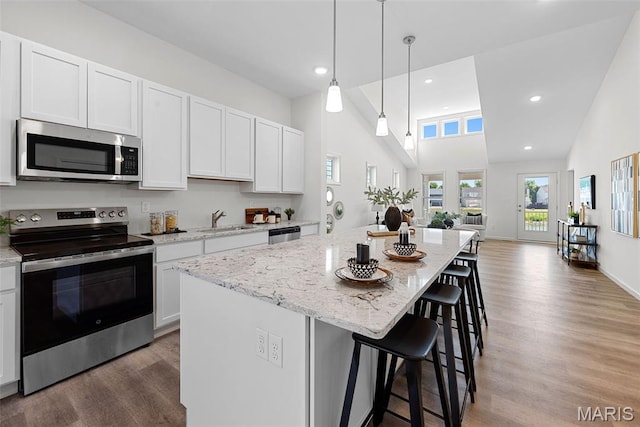 114 Marais Temps Clair, Saint Charles, MO 63301 - kitchen with appliances with stainless steel finishes, light wood finished floors, light stone counters, white cabinets, and recessed lighting