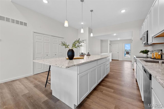 114 Marais Temps Clair, Saint Charles, MO 63301 - kitchen featuring wood finished floors, a center island, white cabinetry, a kitchen breakfast bar, and recessed lighting
