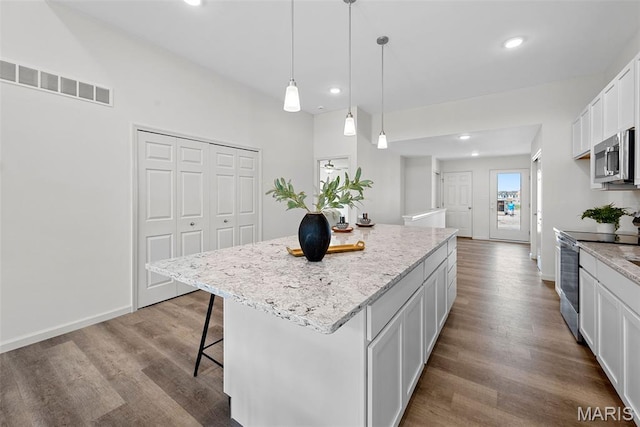 114 Marais Temps Clair, Saint Charles, MO 63301 - kitchen featuring stainless steel appliances, a center island, wood finished floors, a breakfast bar area, and white cabinetry