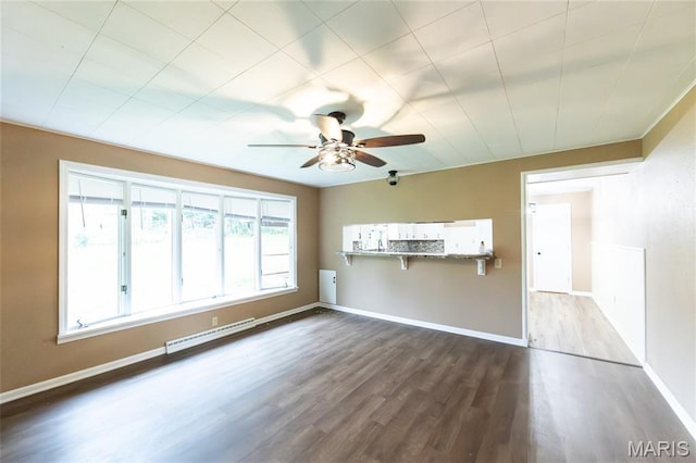 21 Mcfarland Dr, Rolla, MO 65401 - unfurnished living room with baseboard heating, ceiling fan, and dark wood-style floors