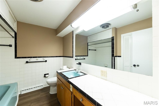 21 Mcfarland Dr, Rolla, MO 65401 - full bath featuring a baseboard radiator, double vanity, a bathtub, wood finished floors, and tile walls