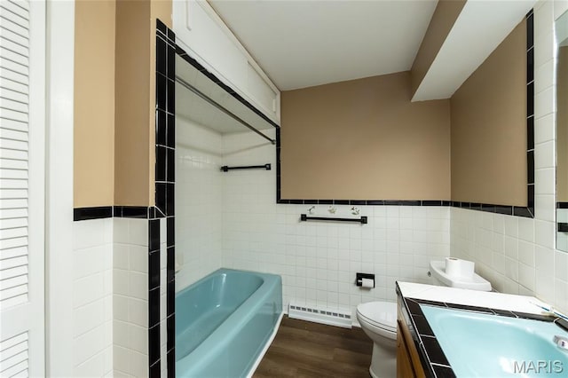 21 Mcfarland Dr, Rolla, MO 65401 - bathroom with tile walls, baseboard heating, wood finished floors, a tub, and vanity