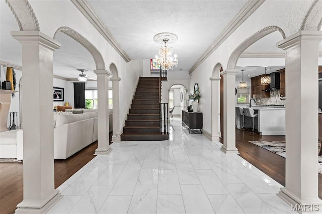1259 Hampton Park Dr, Richmond Heights, MO 63117 - entrance foyer featuring crown molding, light marble finish floors, arched walkways, a ceiling fan, and decorative columns