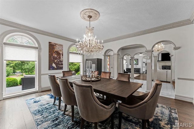 1259 Hampton Park Dr, Richmond Heights, MO 63117 - dining area with decorative columns, arched walkways, a chandelier, ornamental molding, and wood finished floors