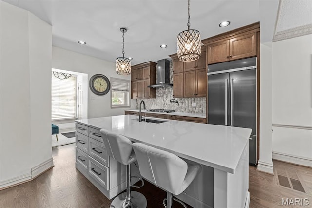 1259 Hampton Park Dr, Richmond Heights, MO 63117 - kitchen featuring built in fridge, wall chimney exhaust hood, backsplash, recessed lighting, and dark wood-type flooring