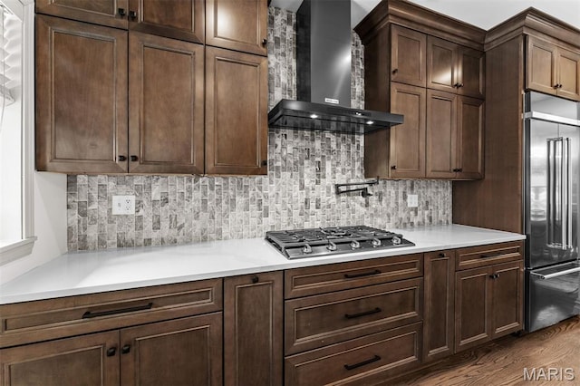 1259 Hampton Park Dr, Richmond Heights, MO 63117 - kitchen with wall chimney range hood, stainless steel appliances, dark wood finished floors, tasteful backsplash, and light countertops