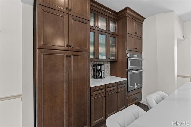 1259 Hampton Park Dr, Richmond Heights, MO 63117 - kitchen featuring double oven, light countertops, glass insert cabinets, and tasteful backsplash