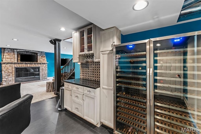 1259 Hampton Park Dr, Richmond Heights, MO 63117 - wine cellar with a glass covered fireplace, wine cooler, dark wood-style flooring, and recessed lighting