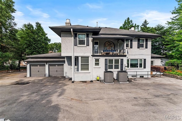 1259 Hampton Park Dr, Richmond Heights, MO 63117 - rear view of property with a balcony, a chimney, a garage, and asphalt driveway