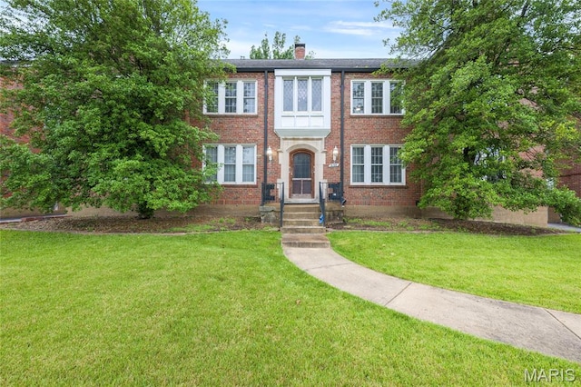 8100 Delmar Blvd Unit 1W, University City, MO 63130 - townhome / multi-family property featuring a chimney, a front lawn, and brick siding