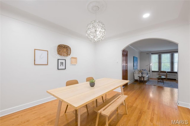 8100 Delmar Blvd Unit 1W, University City, MO 63130 - dining area with arched walkways, light wood finished floors, radiator heating unit, recessed lighting, and a chandelier