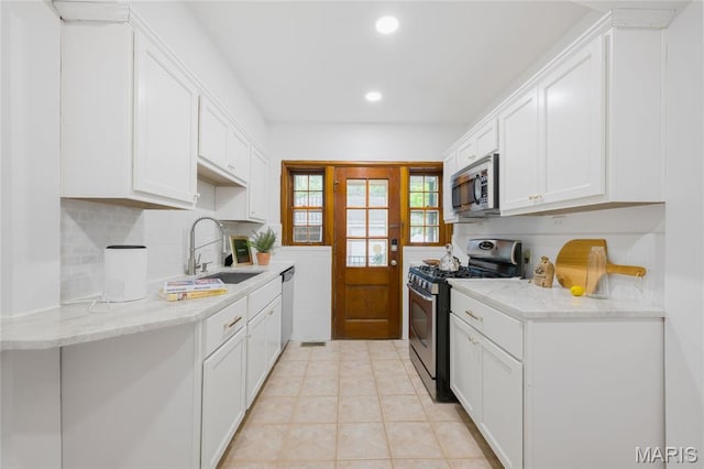 8100 Delmar Blvd Unit 1W, University City, MO 63130 - kitchen with stainless steel appliances, white cabinets, recessed lighting, decorative backsplash, and light tile patterned floors