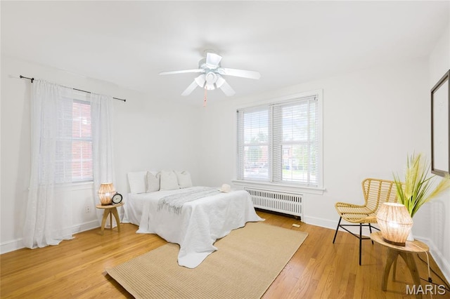 8100 Delmar Blvd Unit 1W, University City, MO 63130 - bedroom with radiator, multiple windows, wood finished floors, and ceiling fan