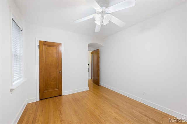 8100 Delmar Blvd Unit 1W, University City, MO 63130 - unfurnished bedroom with arched walkways, light wood-style flooring, and ceiling fan