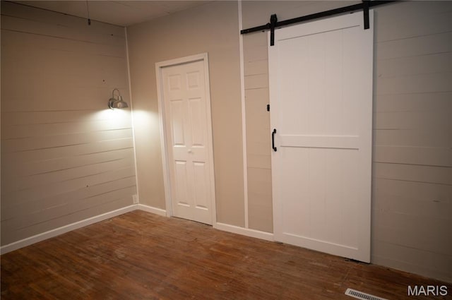 503 N Meramec St, St James, MO 65559 - unfurnished bedroom with wood finished floors and a barn door