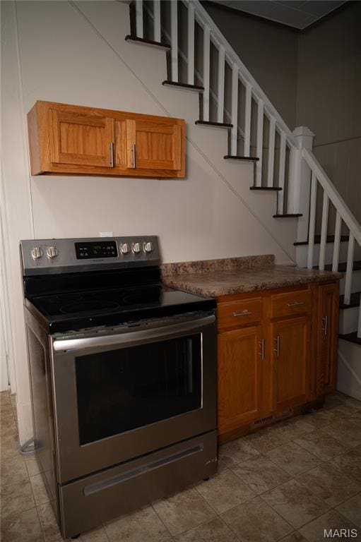 503 N Meramec St, St James, MO 65559 - kitchen featuring stainless steel electric stove, brown cabinetry, and dark countertops