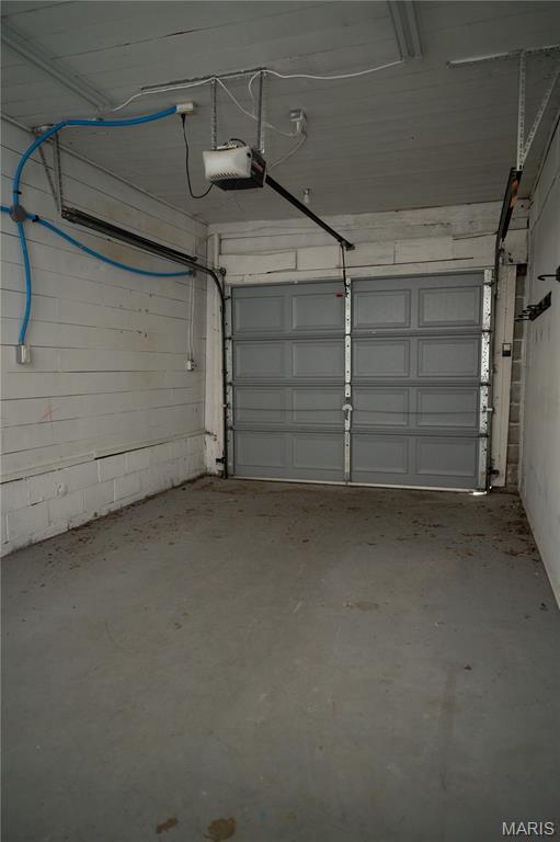 503 N Meramec St, St James, MO 65559 - garage featuring a garage door opener and concrete block wall