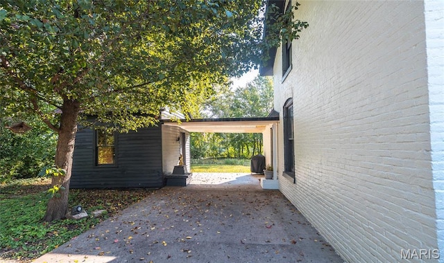 725 W Springfield St, St James, MO 65559 - view of side of property featuring concrete driveway and a carport