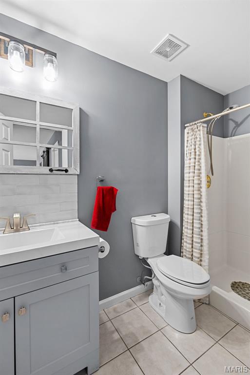 11264 Village Dr, Foristell, MO 63348 - bathroom featuring vanity, tile patterned floors, and a stall shower