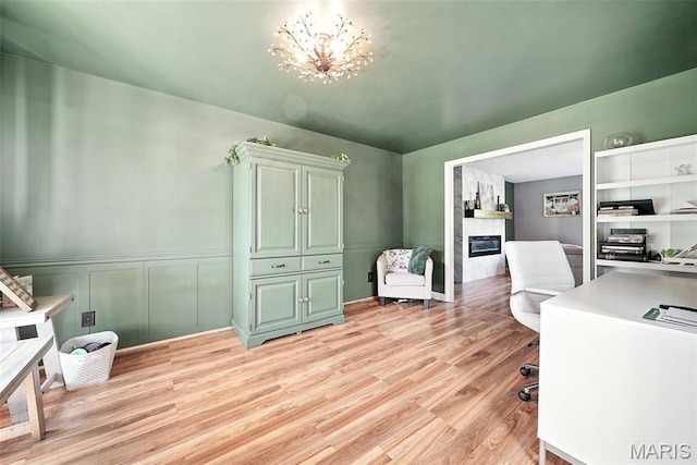 11264 Village Dr, Foristell, MO 63348 - home office with a high end fireplace, light wood finished floors, and a wainscoted wall