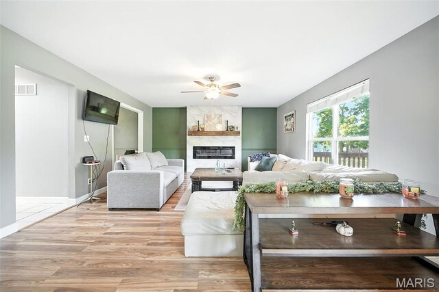 11264 Village Dr, Foristell, MO 63348 - living area with a ceiling fan, a large fireplace, and light wood-style floors