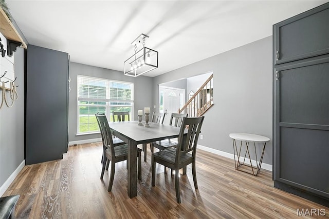 11264 Village Dr, Foristell, MO 63348 - dining room with wood finished floors, stairs, and a chandelier