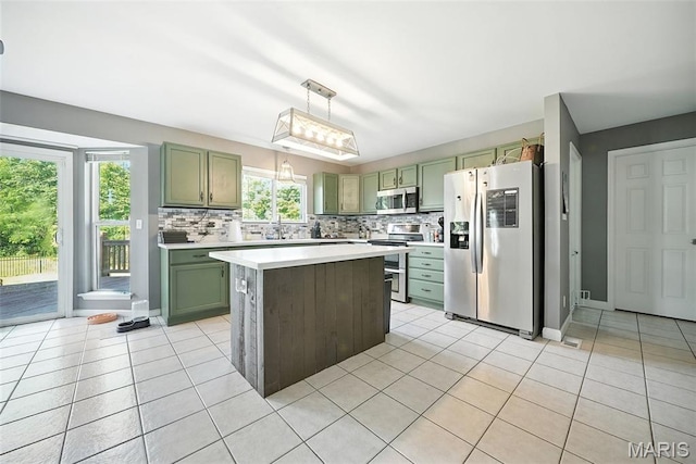 11264 Village Dr, Foristell, MO 63348 - kitchen with stainless steel appliances, green cabinetry, light tile patterned floors, and light countertops