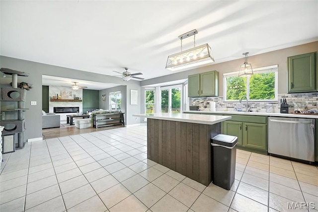 11264 Village Dr, Foristell, MO 63348 - kitchen featuring stainless steel dishwasher, green cabinets, tasteful backsplash, and light tile patterned floors