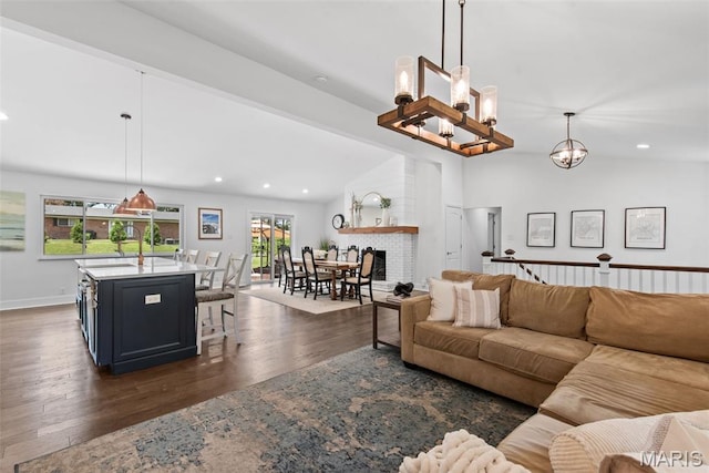 1715 Pine Hill Dr, Des Peres, MO 63131 - living room featuring lofted ceiling, dark wood finished floors, recessed lighting, a chandelier, and a brick fireplace