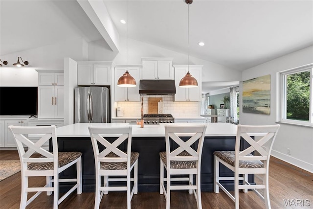 1715 Pine Hill Dr, Des Peres, MO 63131 - kitchen featuring freestanding refrigerator, under cabinet range hood, vaulted ceiling, tasteful backsplash, and light countertops