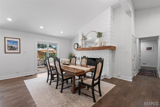 1715 Pine Hill Dr, Des Peres, MO 63131 - dining area featuring a brick fireplace, dark wood-style flooring, high vaulted ceiling, and recessed lighting