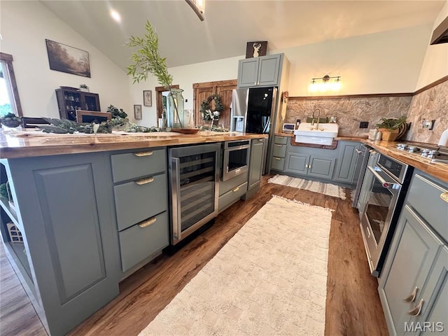 14005 Osage Dr, New London, MO 63459 - kitchen with beverage cooler, gray cabinetry, wood counters, appliances with stainless steel finishes, and lofted ceiling