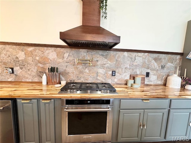 14005 Osage Dr, New London, MO 63459 - kitchen with stainless steel appliances, wall chimney range hood, gray cabinets, and backsplash