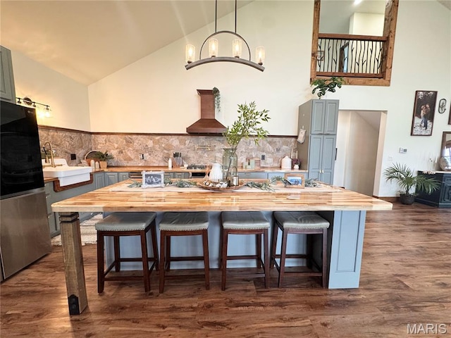 14005 Osage Dr, New London, MO 63459 - kitchen with freestanding refrigerator, butcher block countertops, wall chimney exhaust hood, a chandelier, and high vaulted ceiling