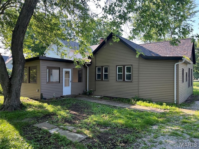 1032 W Pearl St, Staunton, IL 62088 - rear view of property with a chimney, a shingled roof, and a lawn