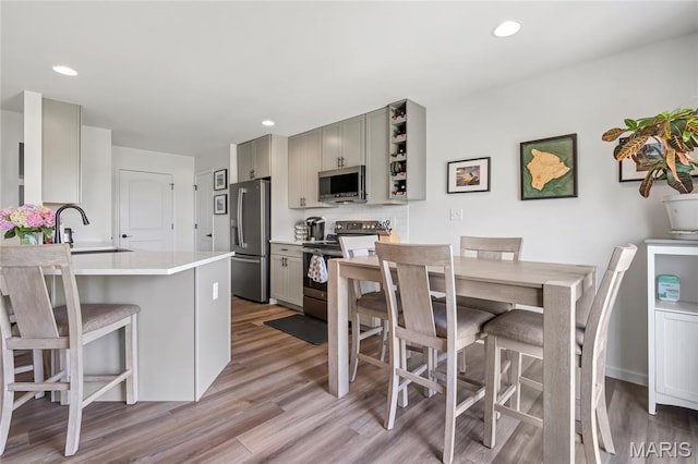 130 Baycrest Ct, Saint Charles, MO 63301 - kitchen with appliances with stainless steel finishes, gray cabinetry, light wood-type flooring, and recessed lighting