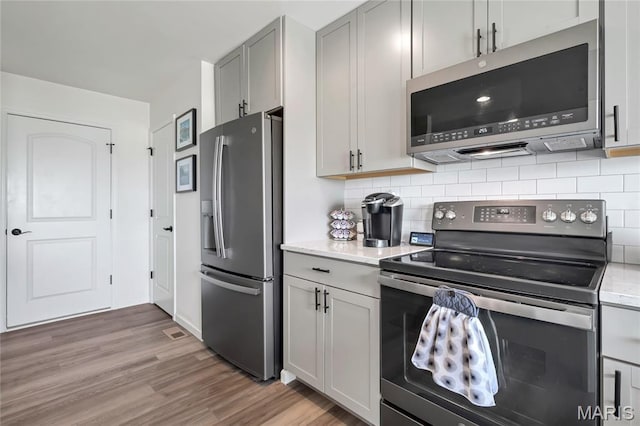 130 Baycrest Ct, Saint Charles, MO 63301 - kitchen featuring stainless steel appliances, light wood-style floors, tasteful backsplash, and gray cabinetry
