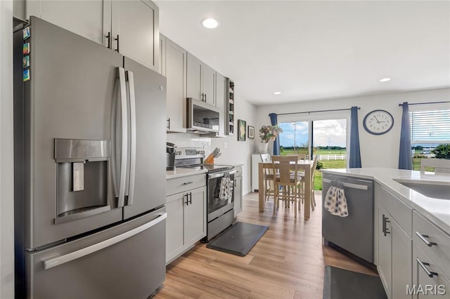 130 Baycrest Ct, Saint Charles, MO 63301 - kitchen with appliances with stainless steel finishes, light countertops, recessed lighting, light wood finished floors, and tasteful backsplash