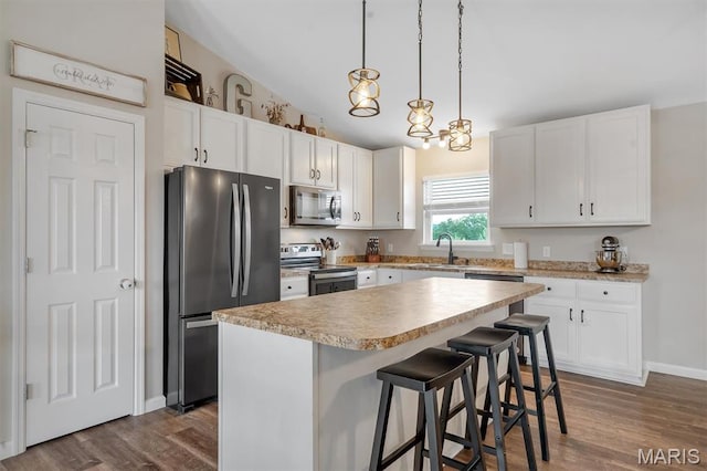 1424 Cortez Dr, Hillsboro, MO 63050 - kitchen with appliances with stainless steel finishes, white cabinetry, dark wood-style floors, and a center island