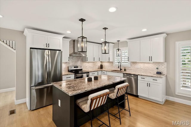 6521 Woodland Dr, Cedar Hill, MO 63016 - kitchen featuring appliances with stainless steel finishes, wall chimney exhaust hood, white cabinets, backsplash, and a kitchen island