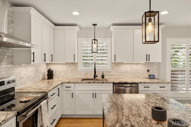 6521 Woodland Dr, Cedar Hill, MO 63016 - kitchen with stainless steel appliances, wall chimney range hood, white cabinetry, light wood-style floors, and recessed lighting