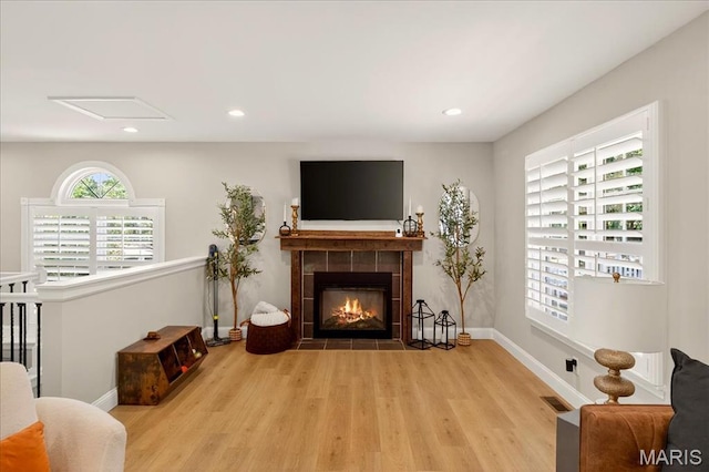 6521 Woodland Dr, Cedar Hill, MO 63016 - living area featuring wood finished floors, a tiled fireplace, and recessed lighting