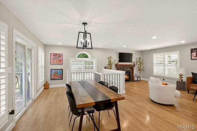 6521 Woodland Dr, Cedar Hill, MO 63016 - dining space featuring light wood-style flooring, recessed lighting, and a warm lit fireplace