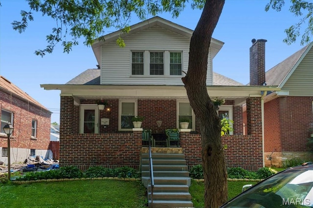 5140 Christy Ave, Saint Louis, MO 63116 - view of front of home featuring brick siding, covered porch, and a front lawn