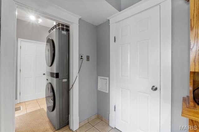 5140 Christy Ave, Saint Louis, MO 63116 - laundry room featuring stacked washer / dryer and light tile patterned floors