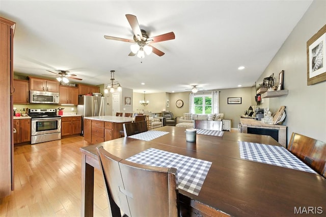 4472 Liberty Ridge Rd, De Soto, MO 63020 - dining area featuring a ceiling fan, light wood finished floors, recessed lighting, and a chandelier