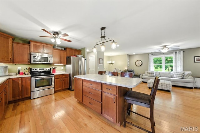 4472 Liberty Ridge Rd, De Soto, MO 63020 - kitchen featuring stainless steel appliances, a ceiling fan, light countertops, and brown cabinets